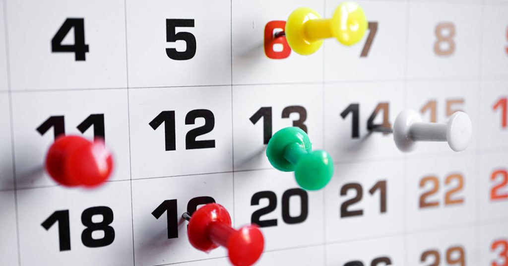 Photo of calendar dates with push pins